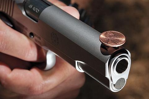 Demonstration of how to dry fire safely with a coin placed on the gun's barrel