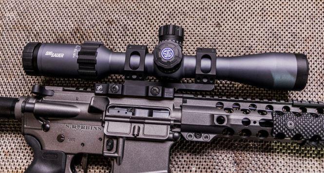 Close-up of an AR-15 rifle with a mounted scope, part of an AR-15 rifle building guide