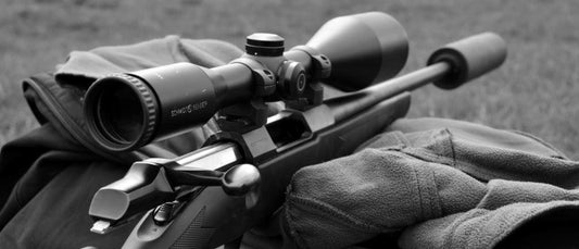 Close-up of a rifle equipped with a night vision scope, illustrating how to choose night vision scope.