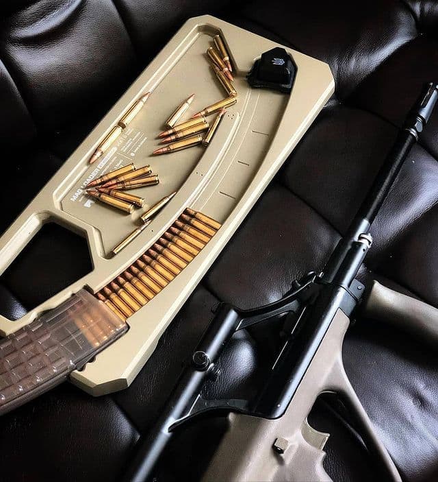 Detailed Steyr AUG rifle guide with rifle, magazine, and ammunition on a leather surface