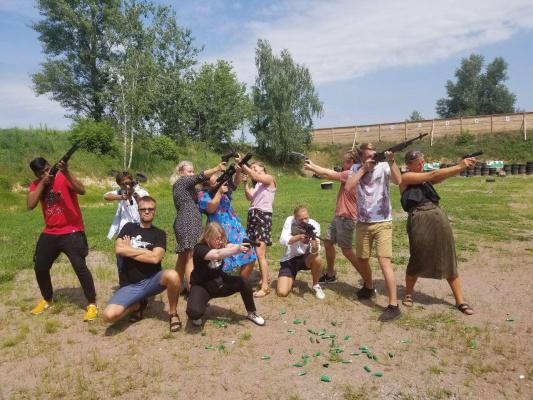 Group of friends enjoying the best shooting ranges Eastern Europe with various firearms at an outdoor range