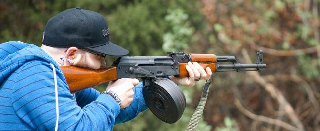 Person aiming an AK47 rifle in a shooting range for the AK47 rifle buying guide