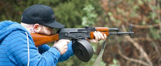 Person aiming an AK47 rifle in a shooting range for the AK47 rifle buying guide