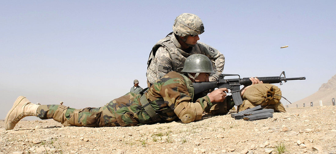 Soldier demonstrating M16 vs AK-47 military choice during training exercise in desert environment