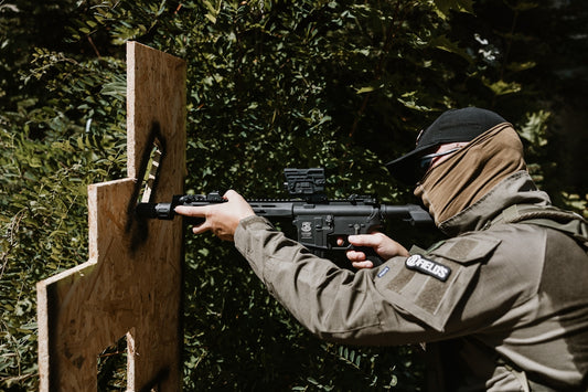 Man aiming rifle at target in woods