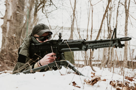 Person in camouflage aims a heavy machine gun.